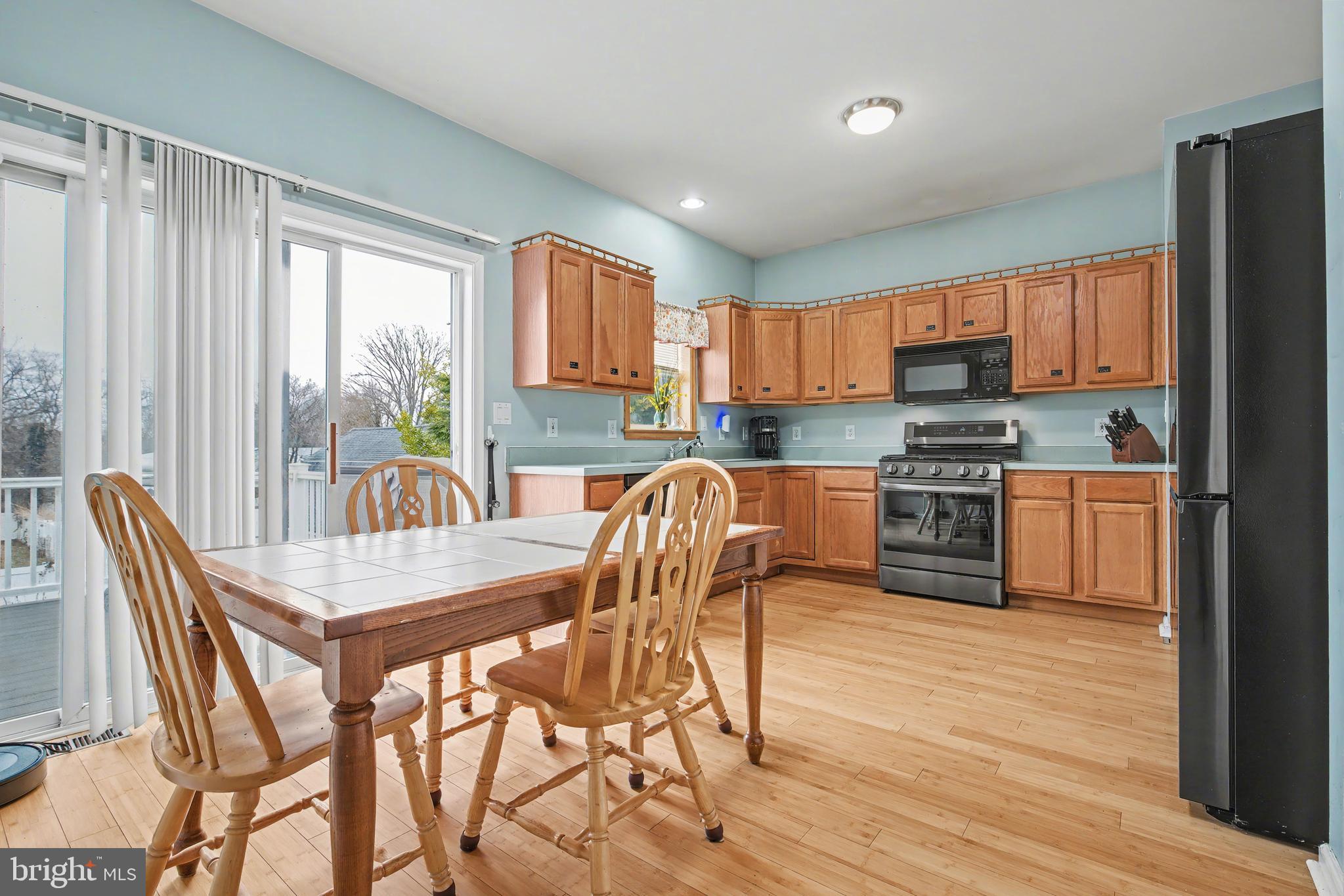 215 Birch Street Hamilton, NJ 08610 - Photo 21 of 38 a kitchen with stainless steel appliances granite countertop a stove top oven a sink dishwasher a dining table and chairs with wooden floor