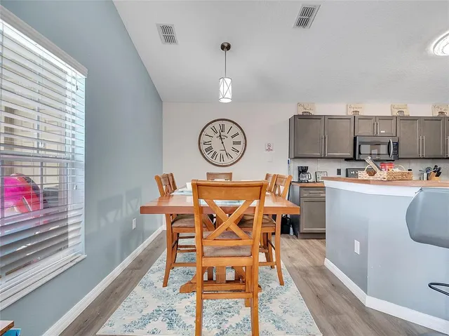 a view of a kitchen with fridge and wooden floor
