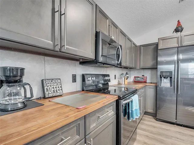 a kitchen with stainless steel appliances granite countertop a sink a stove and cabinets