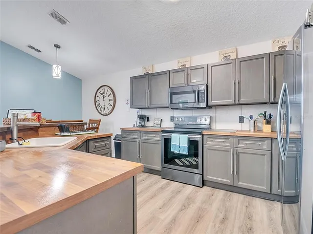 a kitchen with stainless steel appliances sink stove and cabinets