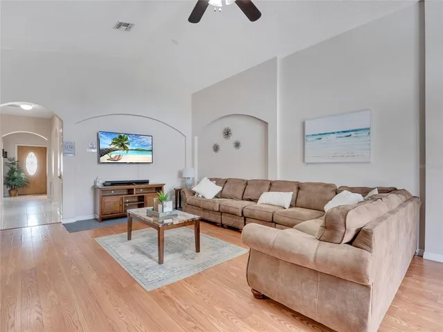 a living room with furniture and a wooden floor