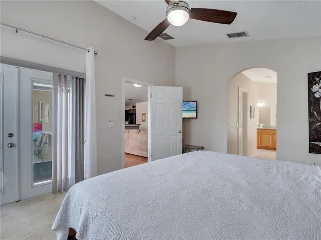 a large bedroom with closet and chandelier fan