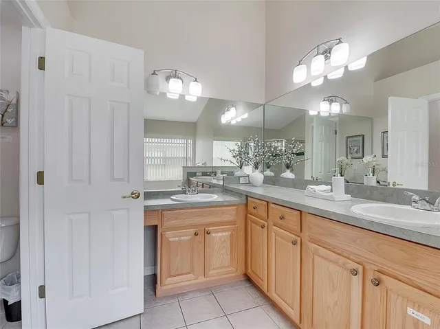 a kitchen with white cabinets and chandelier