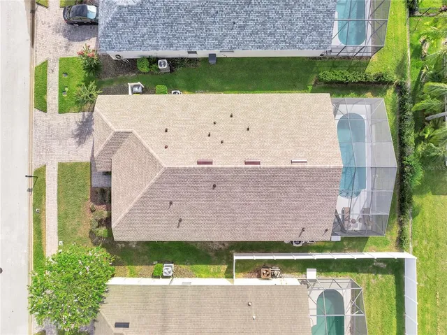 an aerial view of a house with a yard and lake view