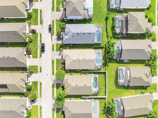 an aerial view of residential houses with outdoor space and parking