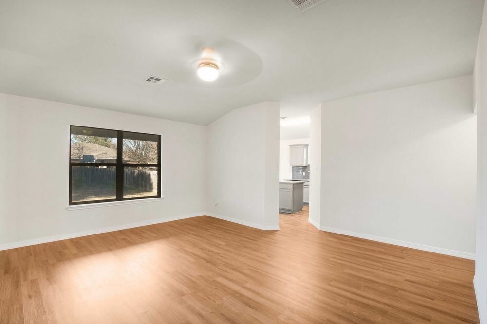 3310 Blue Ridge Drive Round Rock, TX 78681 - Photo 6 of 13 Luminous living space featuring durable hardwood flooring and a bright ceiling light fixture.