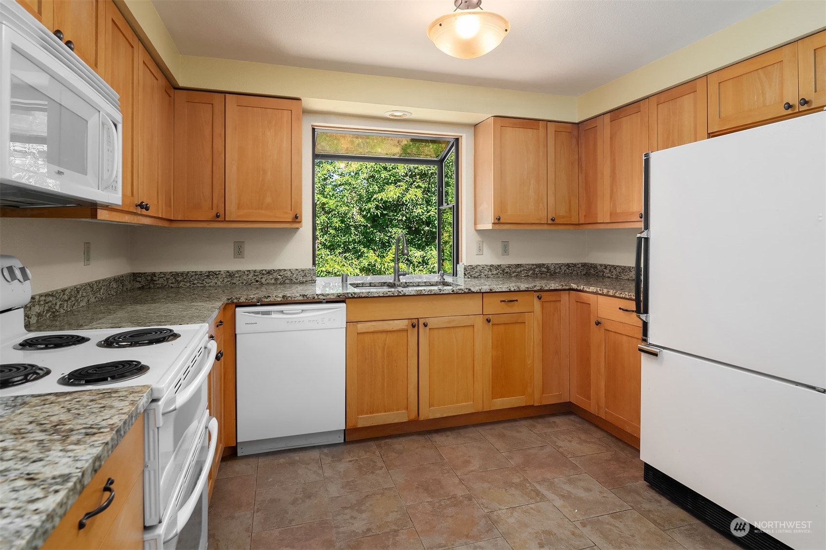 15412 Southeast 176th Place Renton, WA 98058 - Photo 4 of 6 a kitchen with stainless steel appliances granite countertop a stove a sink dishwasher and a refrigerator