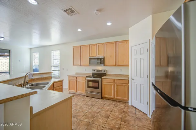 a kitchen with stainless steel appliances granite countertop a stove refrigerator and a sink