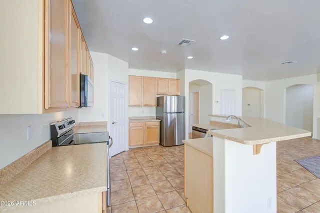 a kitchen with stainless steel appliances granite countertop a sink and a refrigerator