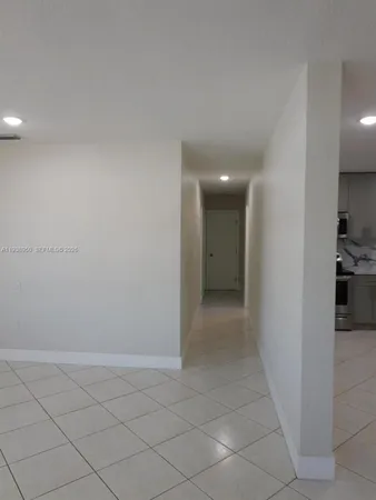 a view of hallway with a window and a kitchen