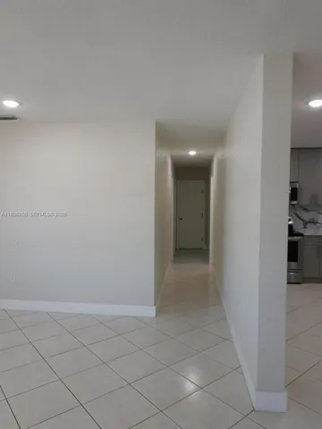 a view of hallway with a window and a kitchen