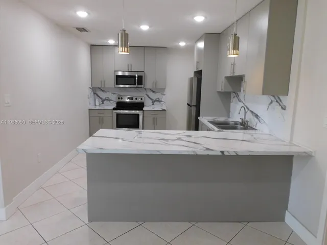a kitchen with kitchen island granite countertop a sink and a stove