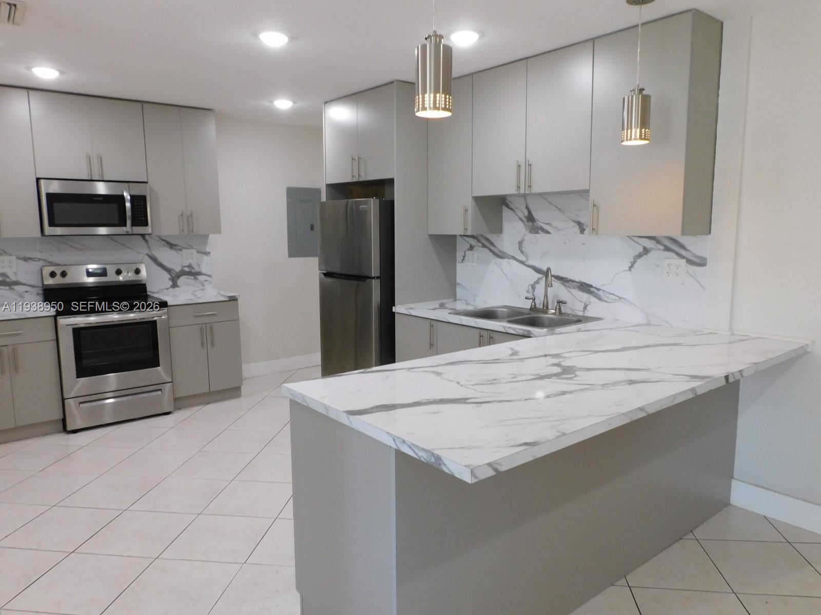 846 West 31st Street Hialeah, FL 33012 - Photo 7 of 21 Remodeled Kitchen with SS Appliances and Quartz Countertops/Backsplash. Breakfast snack counter.