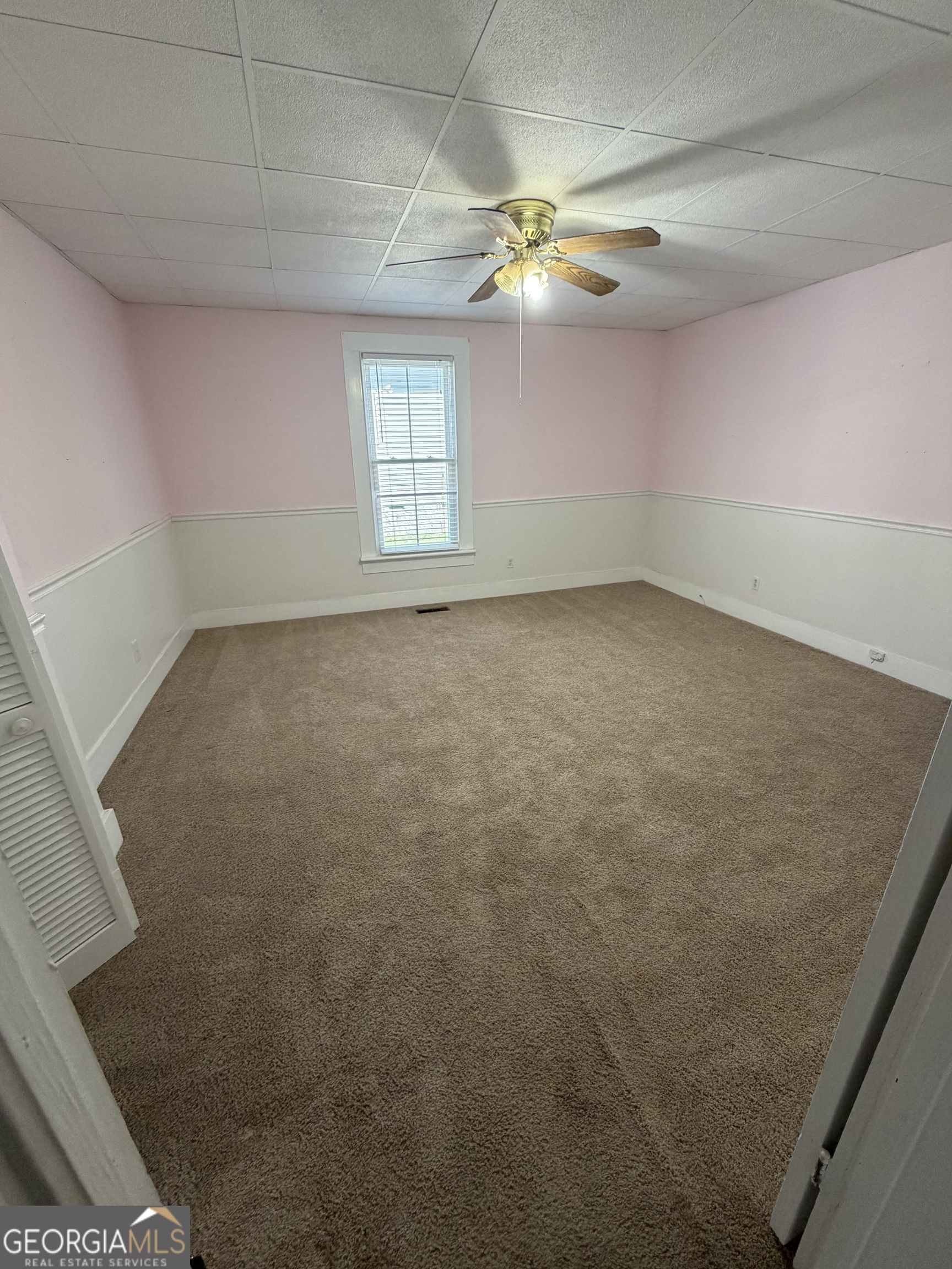 151 Tusten Street Elberton, GA 30635 - Photo 17 of 30 en empty room with windows and chandelier fan