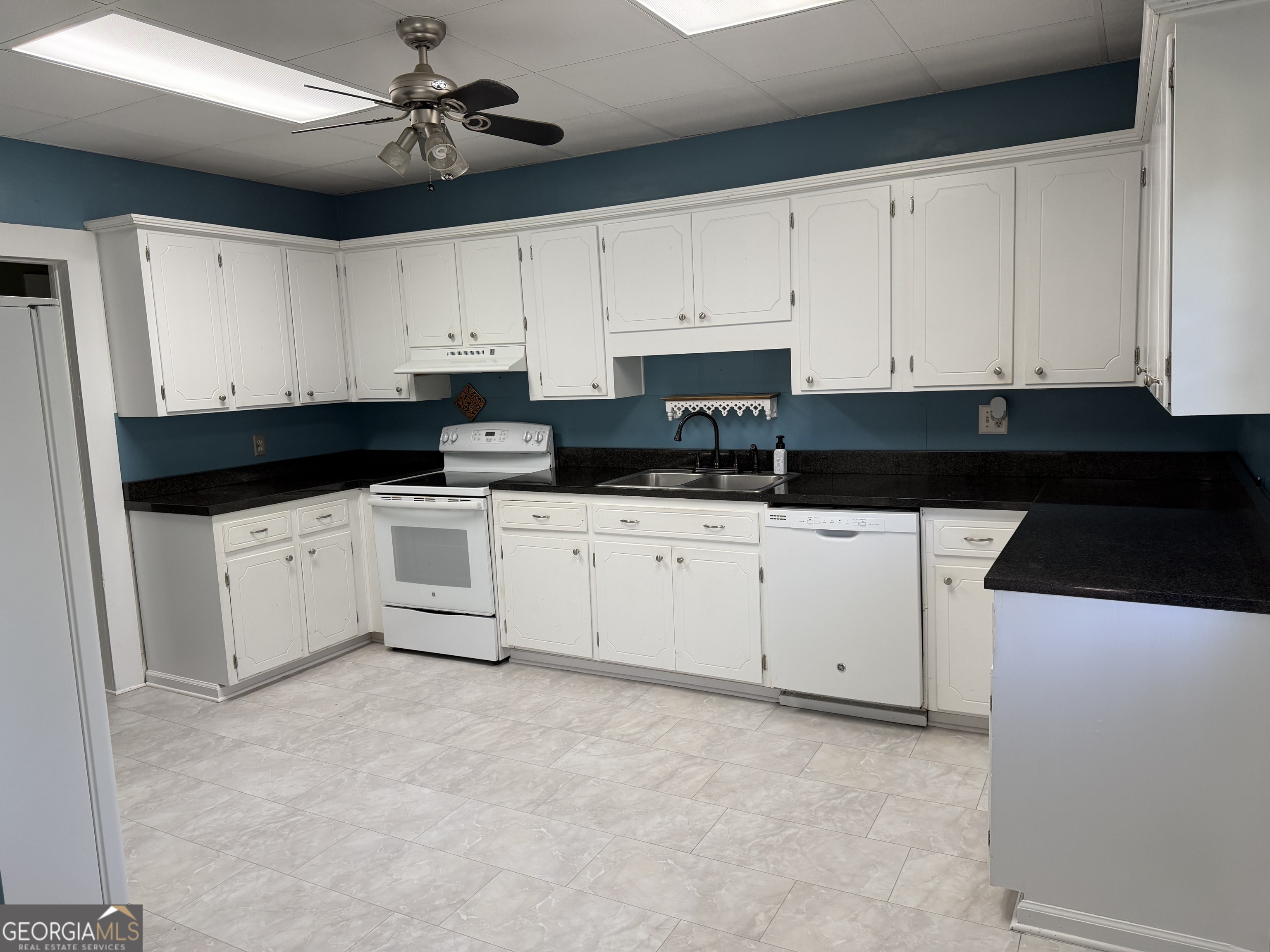 151 Tusten Street Elberton, GA 30635 - Photo 7 of 30 a kitchen with granite countertop a sink a stove and cabinets