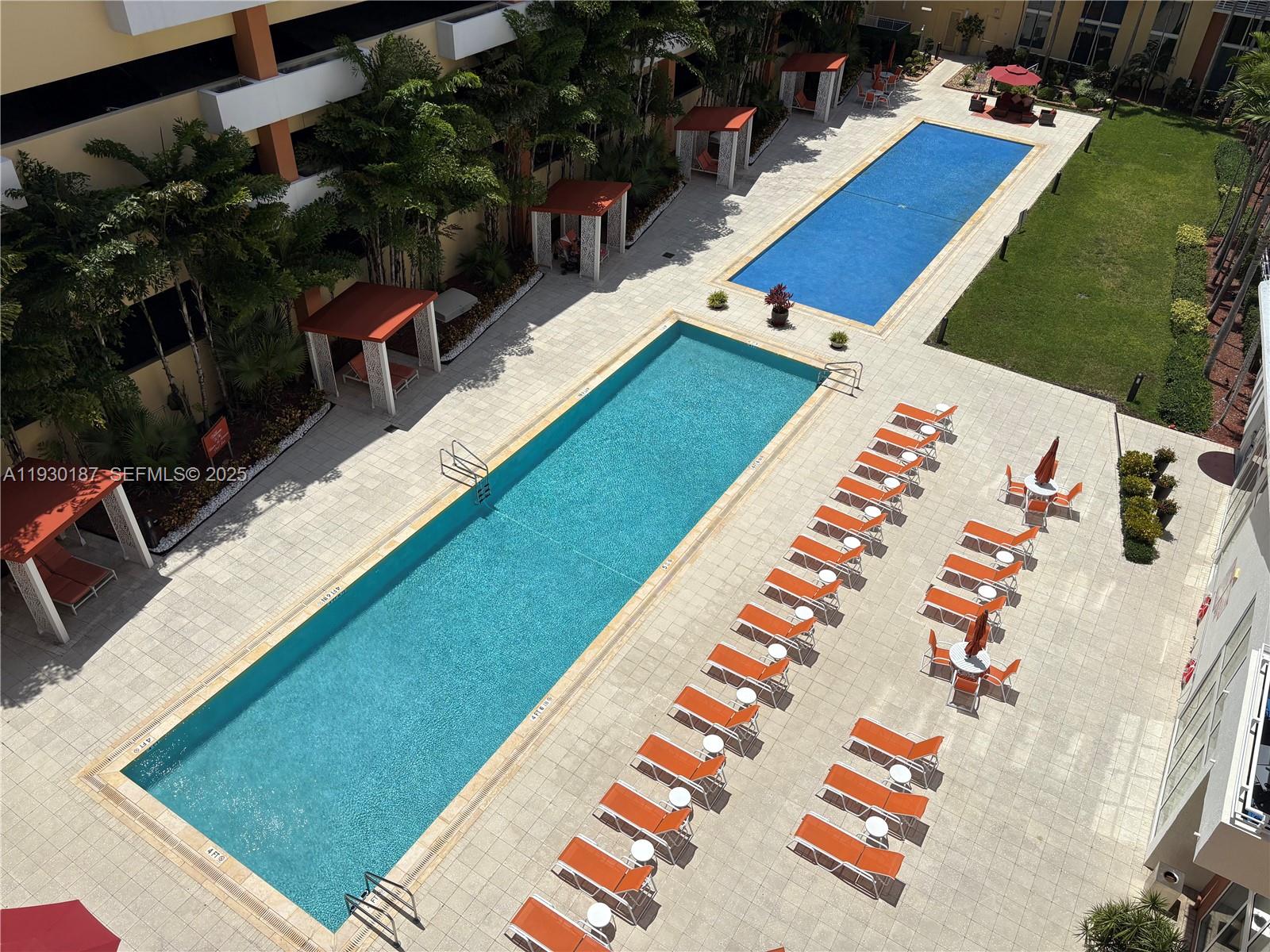 a view of swimming pool with chairs and wooden fence