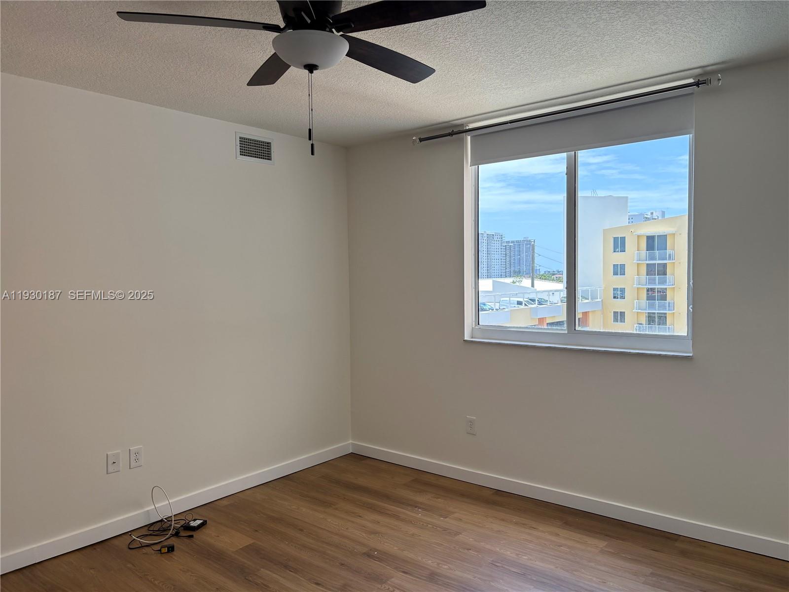 2775 Northeast 187th Street, Unit 628 Aventura, FL 33180 - Photo 11 of 19 a view of an empty room with a window and wooden floor