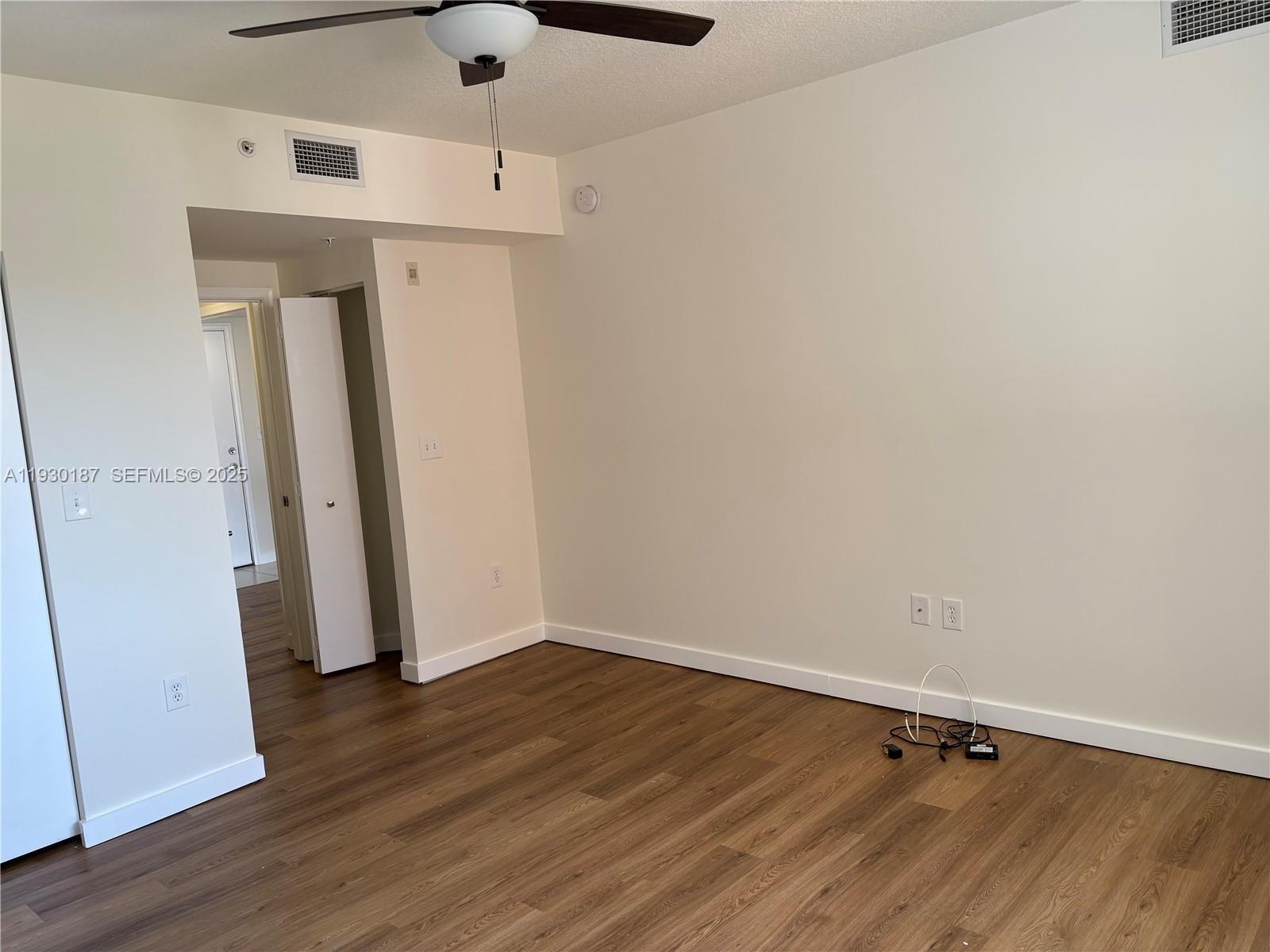 2775 Northeast 187th Street, Unit 628 Aventura, FL 33180 - Photo 12 of 19 an empty room with wooden floor and a ceiling fan
