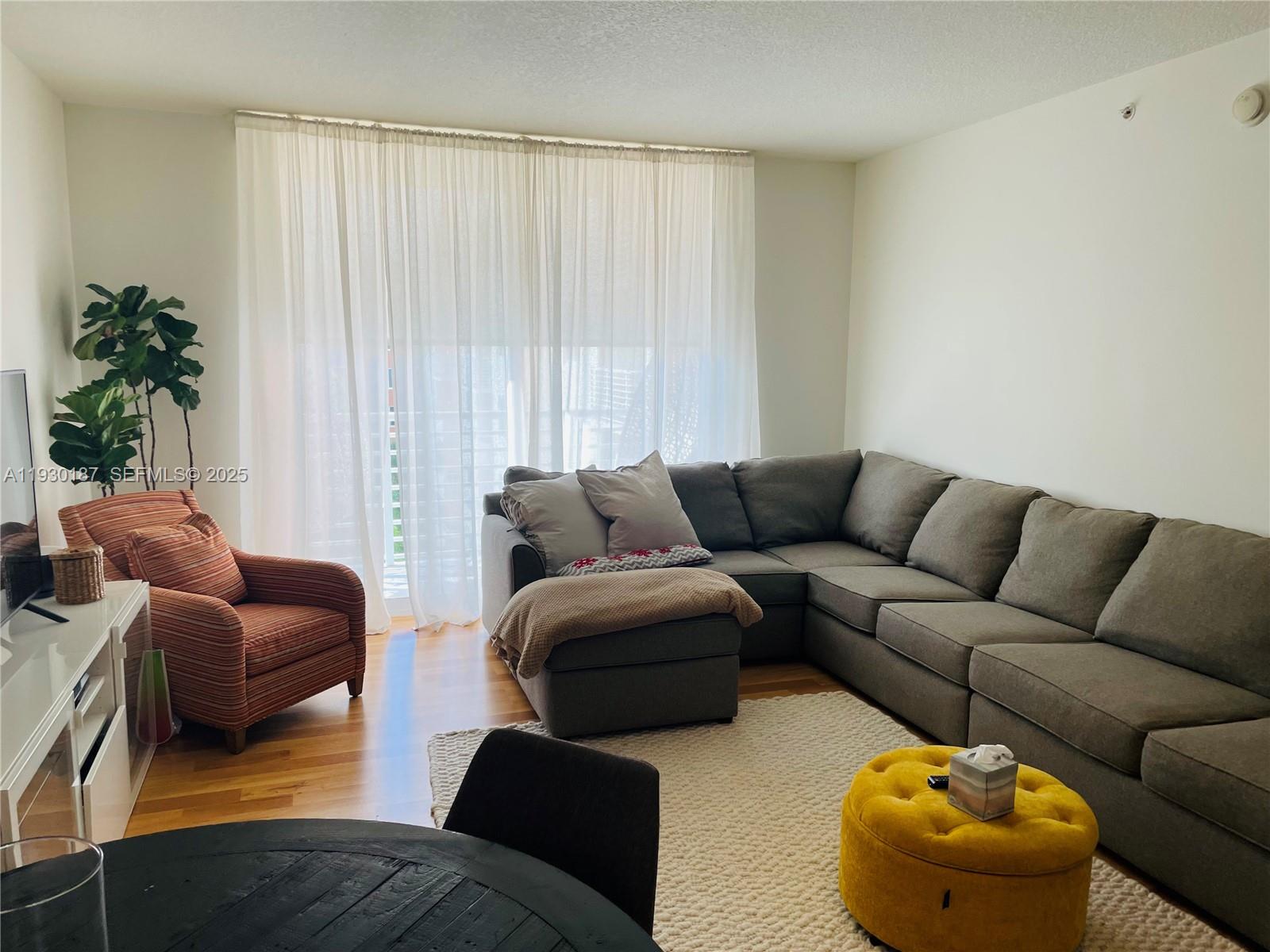 2775 Northeast 187th Street, Unit 628 Aventura, FL 33180 - Photo 15 of 19 a living room with furniture and a large window
