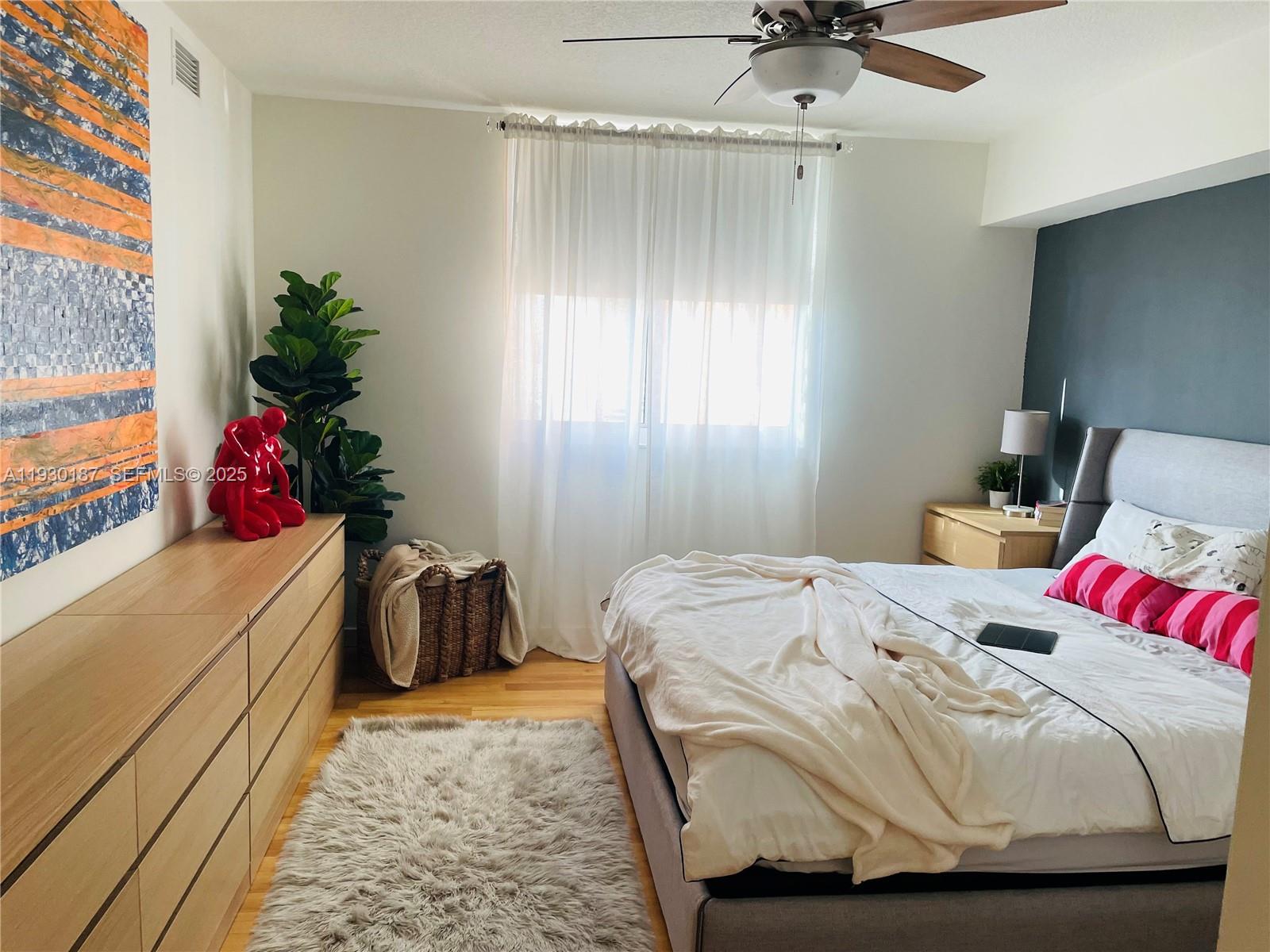 2775 Northeast 187th Street, Unit 628 Aventura, FL 33180 - Photo 17 of 19 a bedroom with a bed and a chandelier