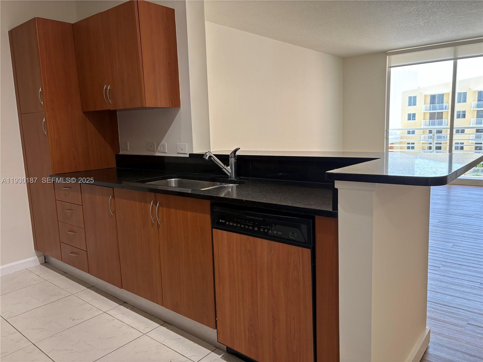2775 Northeast 187th Street, Unit 628 Aventura, FL 33180 - Photo 4 of 19 a kitchen with granite countertop cabinets and sink