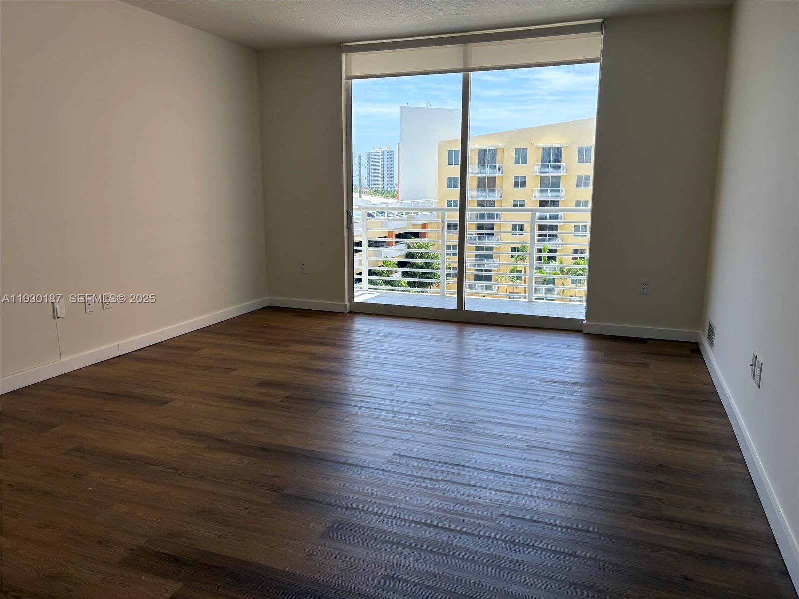 2775 Northeast 187th Street, Unit 628 Aventura, FL 33180 - Photo 7 of 19 a view of an empty room with wooden floor and a window