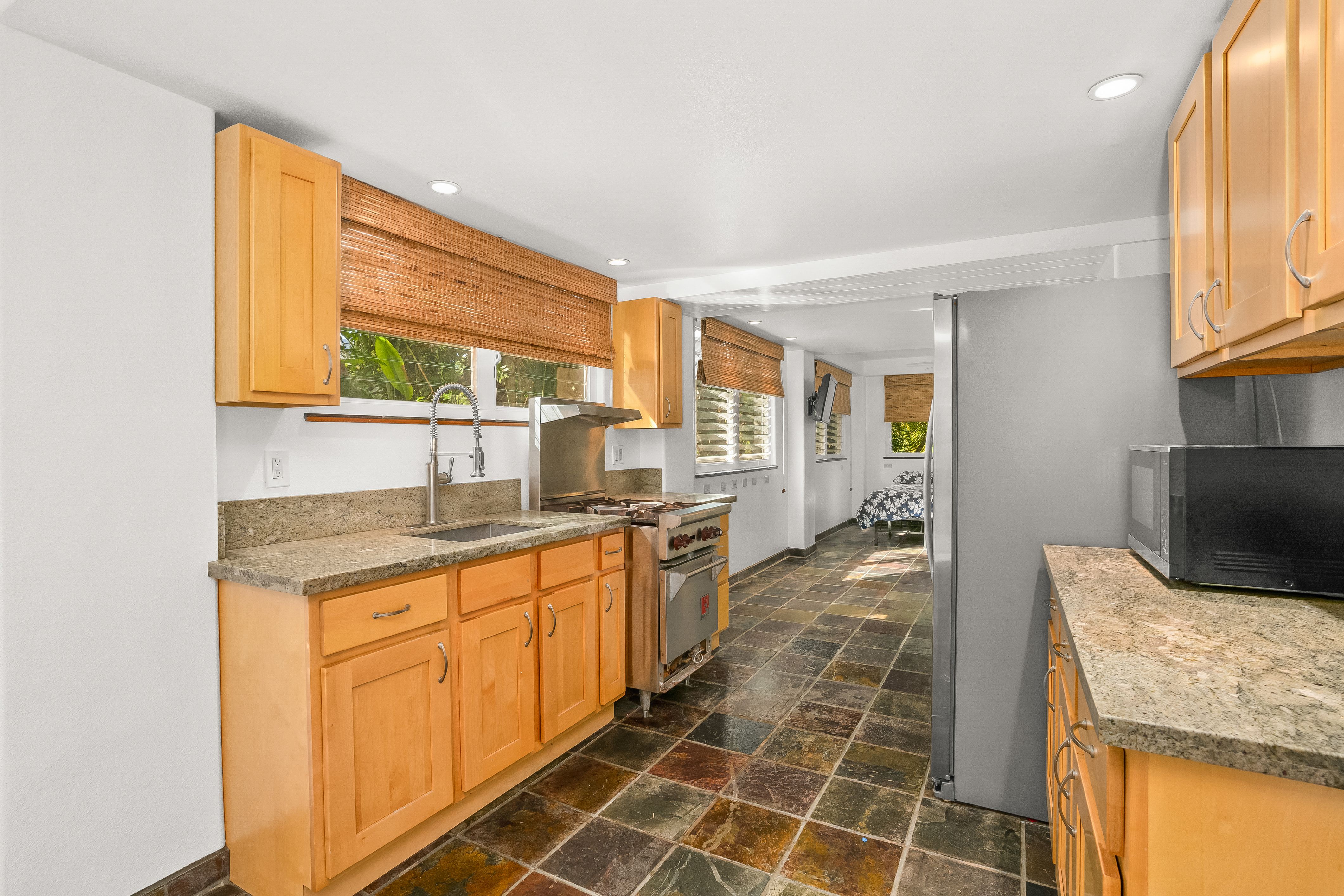 4485 Pilikoa Street Hanalei, HI 96714 - Photo 23 of 30 a large bathroom with a granite countertop sink a mirror and a shower