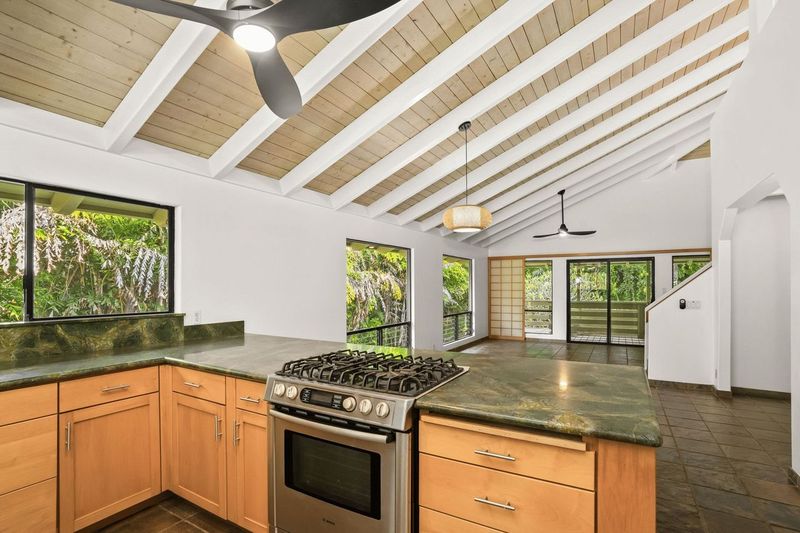 4485 Pilikoa Street Hanalei, HI 96714 - Photo 8 of 30 a kitchen with stainless steel appliances granite countertop a stove a sink and a granite counter tops with a large window