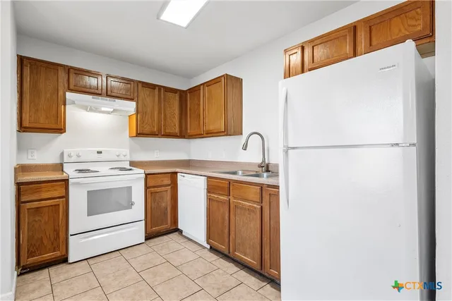 a kitchen with white cabinets and white appliances