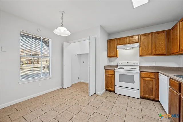a kitchen with a refrigerator and white cabinets