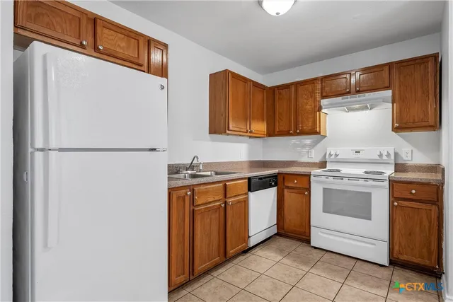 a kitchen with a stove top oven sink and cabinets