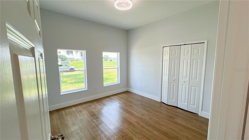6741 Heavitree Drive Sebring, FL 33876 - Photo 12 of 29 an empty room with wooden floor and windows