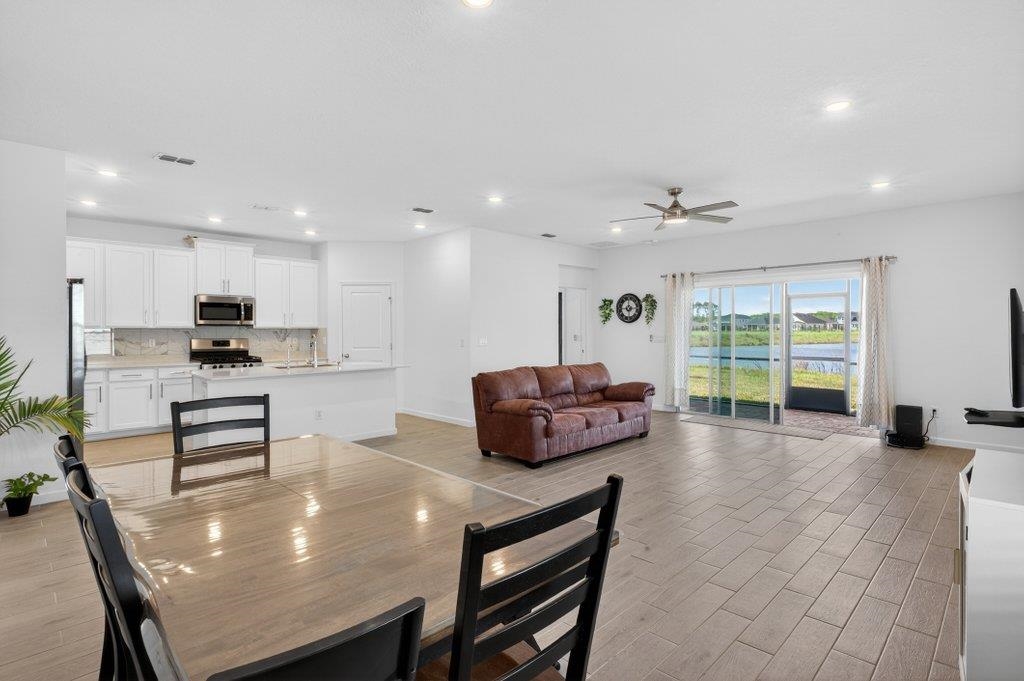 210 White Rabbit Run St. Augustine, FL 32092 - Photo 36 of 85 a kitchen with a table chairs refrigerator and cabinets