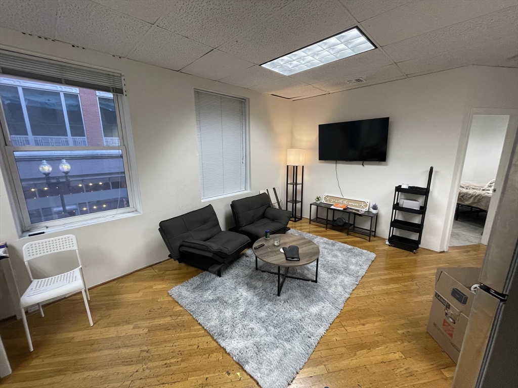 28 Kingston Street, Unit 2 Boston, MA 02110 - Photo 2 of 7 a living room with furniture and a flat screen tv
