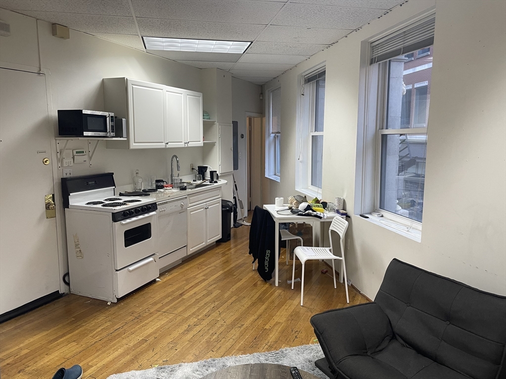 28 Kingston Street, Unit 2 Boston, MA 02110 - Photo 3 of 7 a kitchen with a sink appliances and cabinets