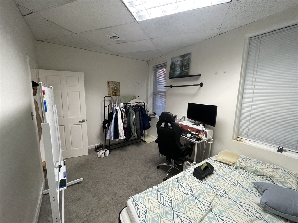 28 Kingston Street, Unit 2 Boston, MA 02110 - Photo 4 of 7 a bedroom with a bed and a chair