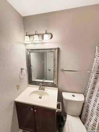 a bathroom with a sink vanity mirror and toilet