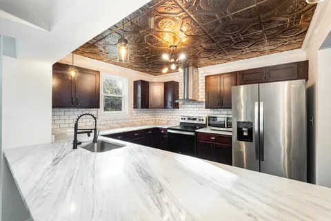 a kitchen with granite countertop stainless steel appliances a sink cabinets and a counter top space