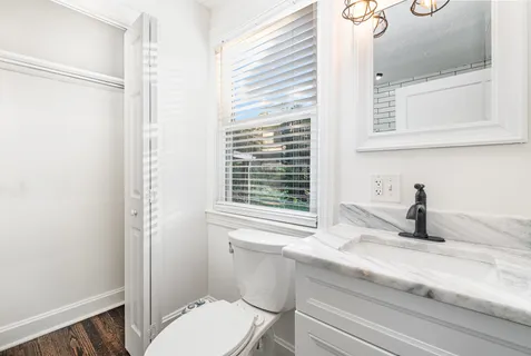a bathroom with a granite countertop sink toilet and shower