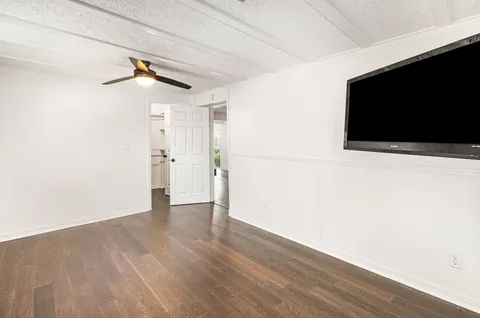 a view of a livingroom with wooden floor and a flat screen tv