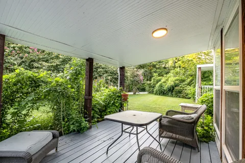 a view of a porch with furniture and wooden floor