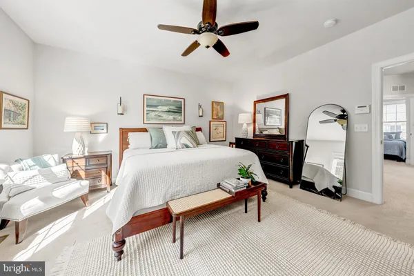 a bedroom with a bed a chandelier and a couch