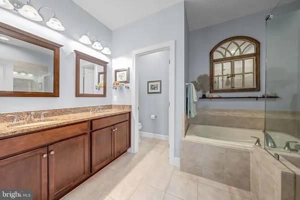 a spacious bathroom with a tub sink and mirror