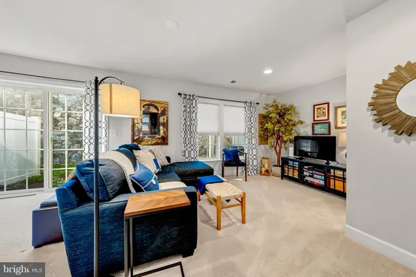 a living room with furniture a flat screen tv and a large window