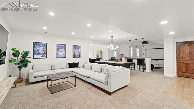 13625 Random Ridge View Colorado Springs, CO 80921 - Photo 24 of 50 Living area with recessed lighting, light colored carpet, and a chandelier