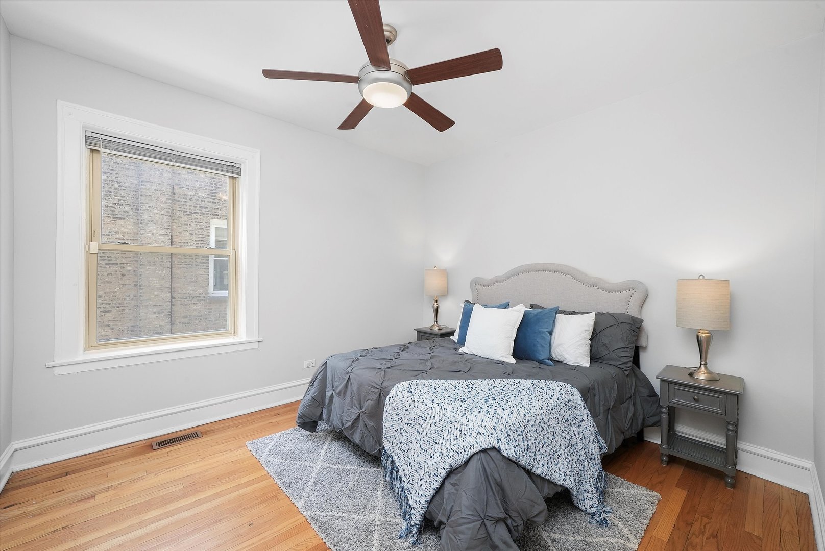 1928 West Addison Street, Unit 1S Chicago, IL 60613 - Photo 13 of 25 a bedroom with a bed and wooden floor
