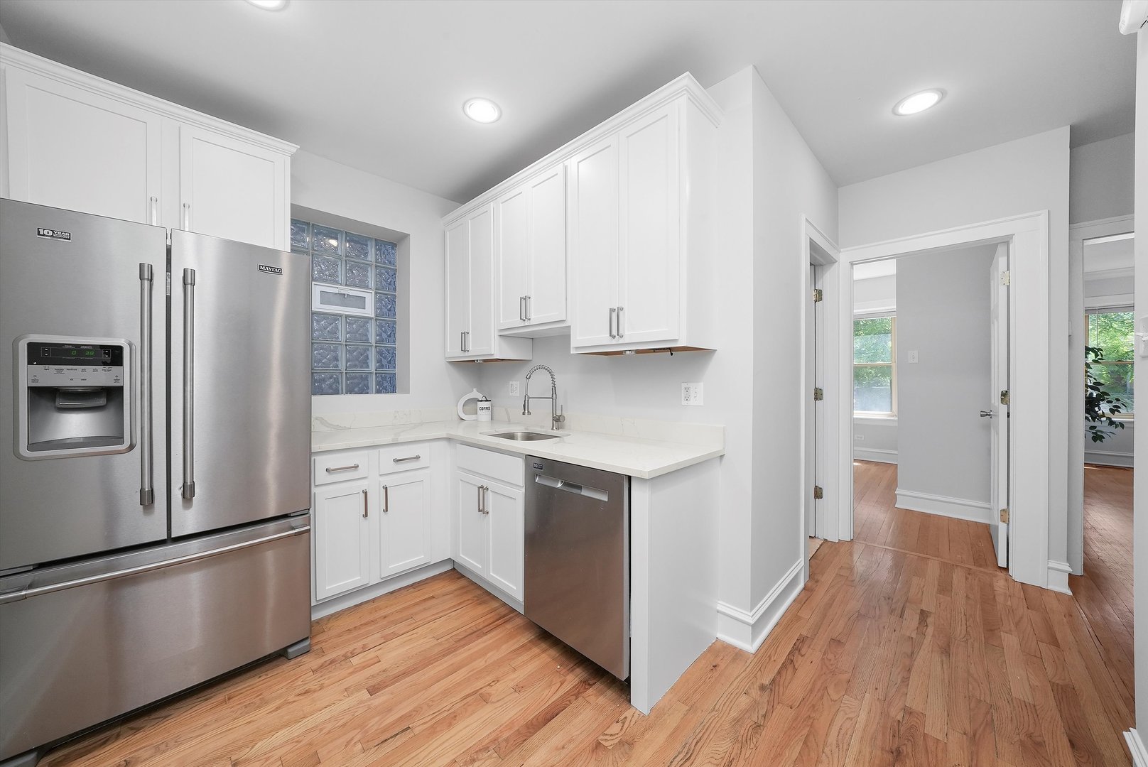 1928 West Addison Street, Unit 1S Chicago, IL 60613 - Photo 3 of 25 a kitchen with a refrigerator a sink and wooden floor