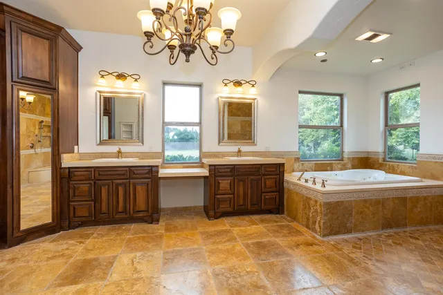 a spacious bathroom with a tub sink and mirror