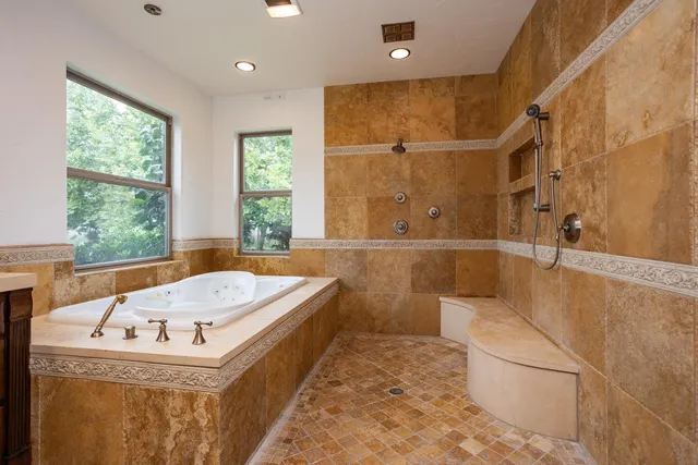 a bathroom with a tub sink and mirror