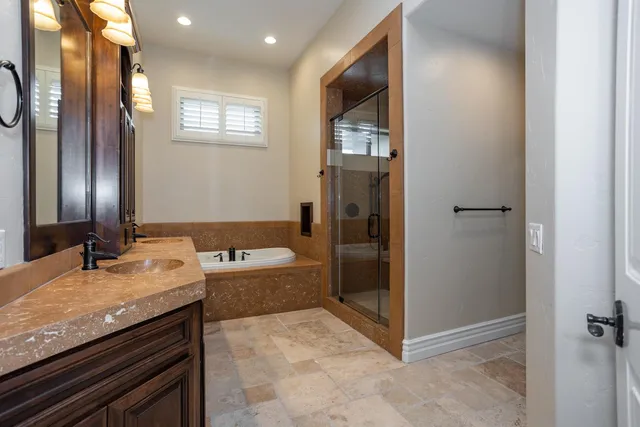 a bathroom with double vanity and a bathtub